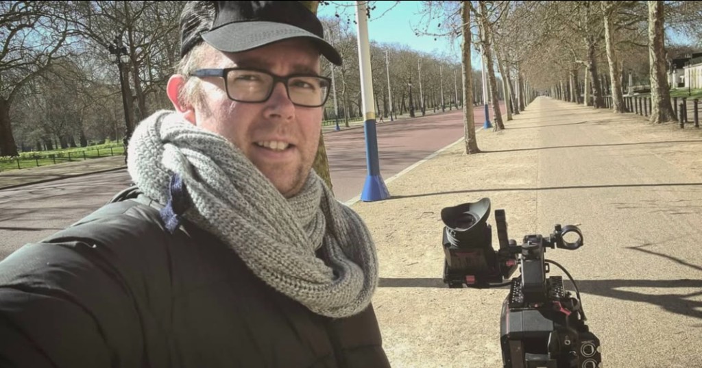 James Ian Gray outdoors with a professional cinema camera on a tree-lined path
