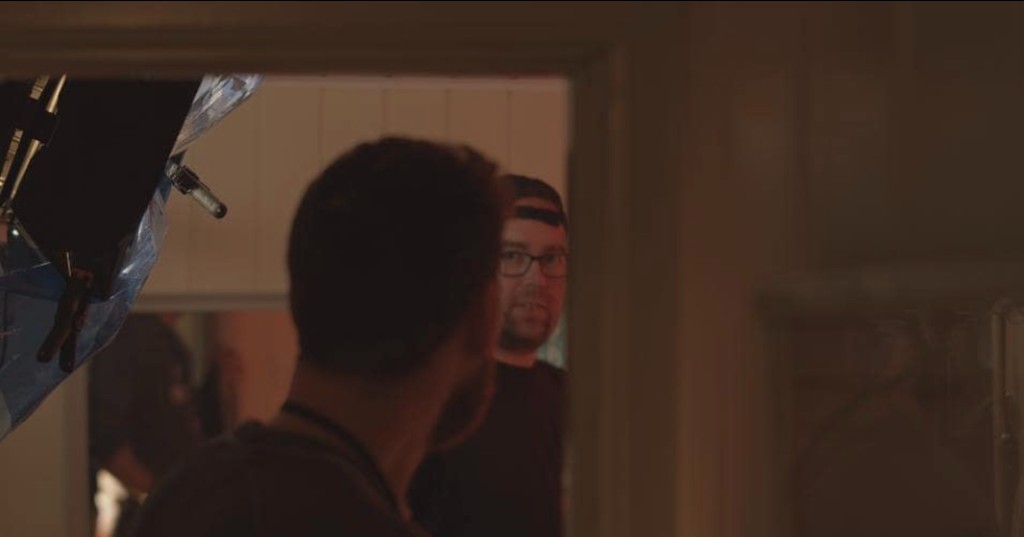 James Ian Gray on set, framed in a doorway